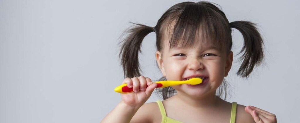 A little girl brushing her teeth.