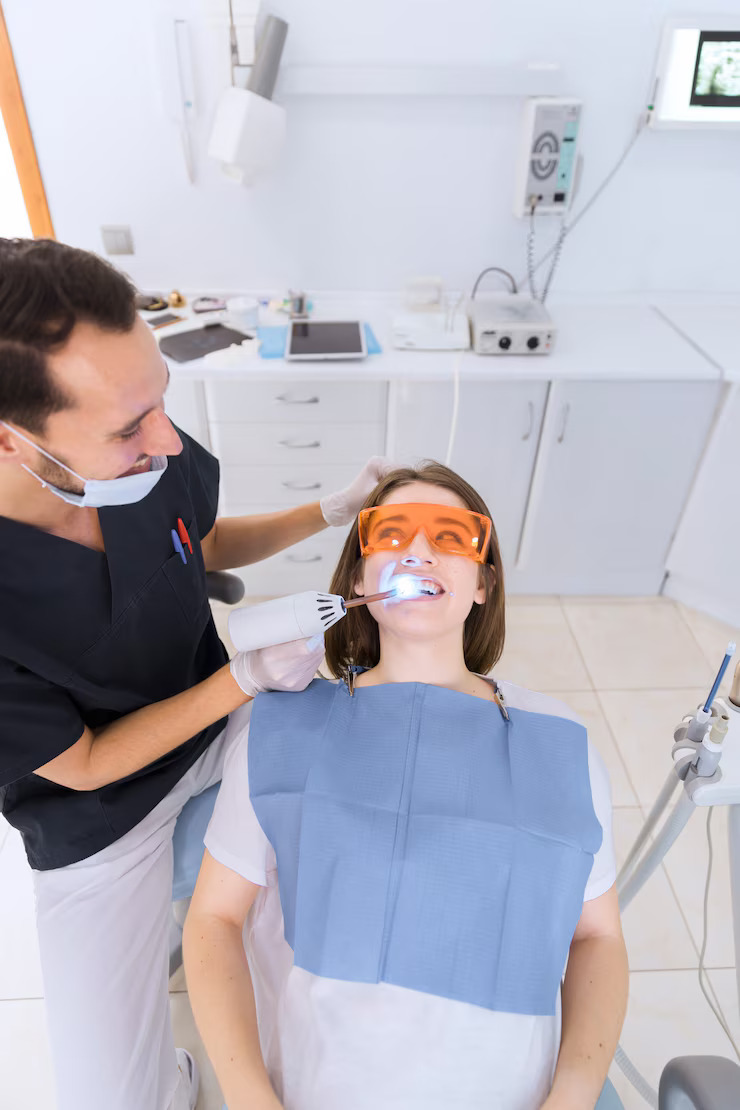 Cosmetic dentist performing in-chair teeth whitening treatment in Canberra dental clinic